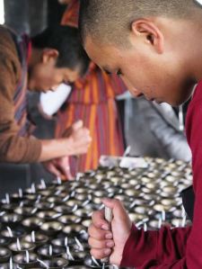 Monks lighting votives